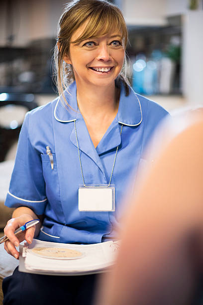 istock Midwife on home visit checking through patients medical notes 467292664