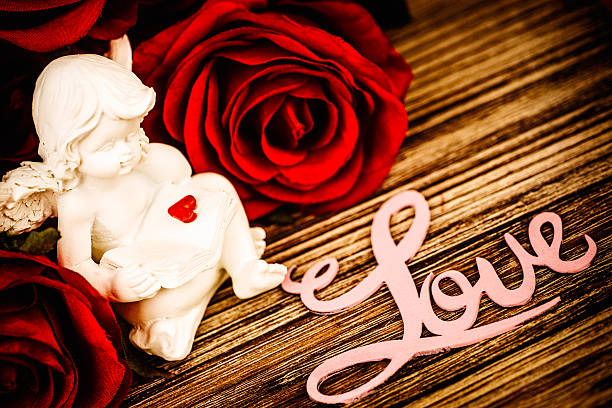 cupido querubín rojas y rosas - wood single flower flower bouquet fotografías e imágenes de stock