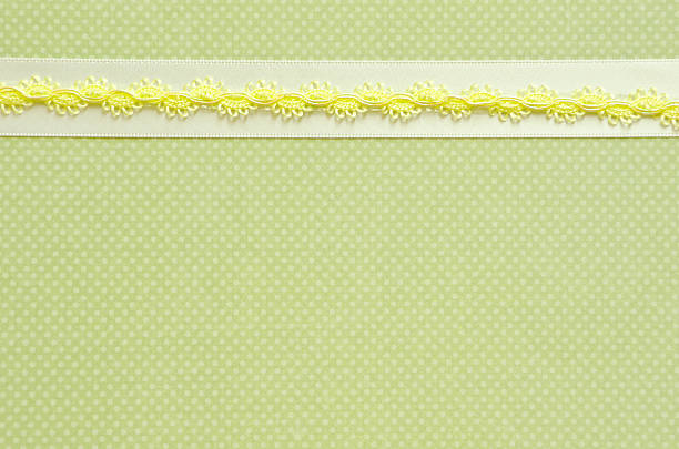 Pretty ribbon border on green colored paper that can be used as a background for scrapbooking, cards, or invitations