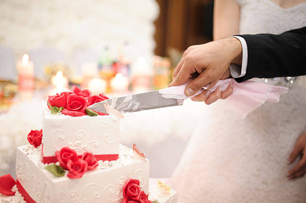 istock bride and groom are Slicing the wedding cake on reception 467298808