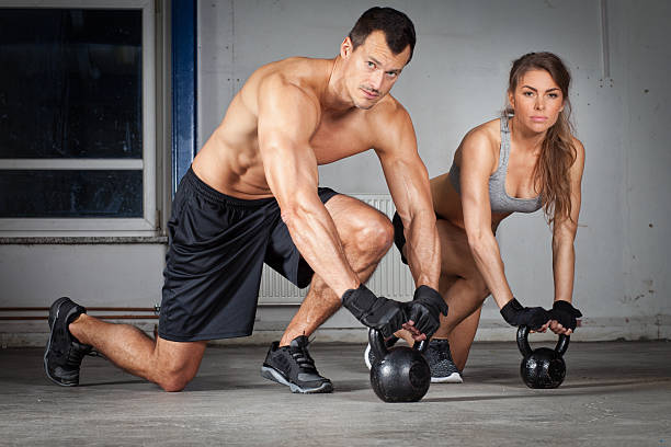 kettlebell training man and woman stock photo