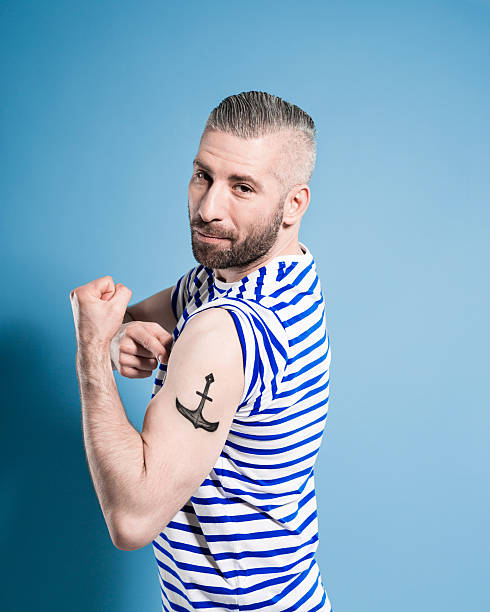 marinaio barbuto uomo con tatoo sua ancora - arm tattoo foto e immagini stock