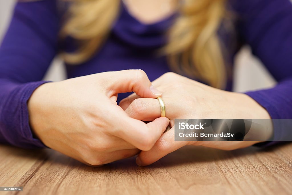 Woman is taking off the wedding ring woman is taking off the wedding ring Breaking Stock Photo