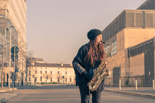 istock Beautiful young woman playing tenor saxophone 467302116