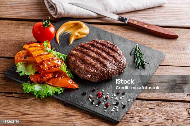 Burger Grill With Vegetables And Sauce On A Wooden Surface Stock Photo - Download Image Now