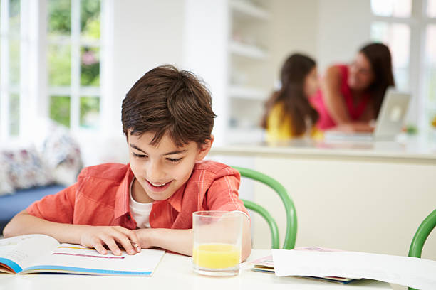 istock Boy Doing Homework As Mother And Daughter uses Laptop 467303987