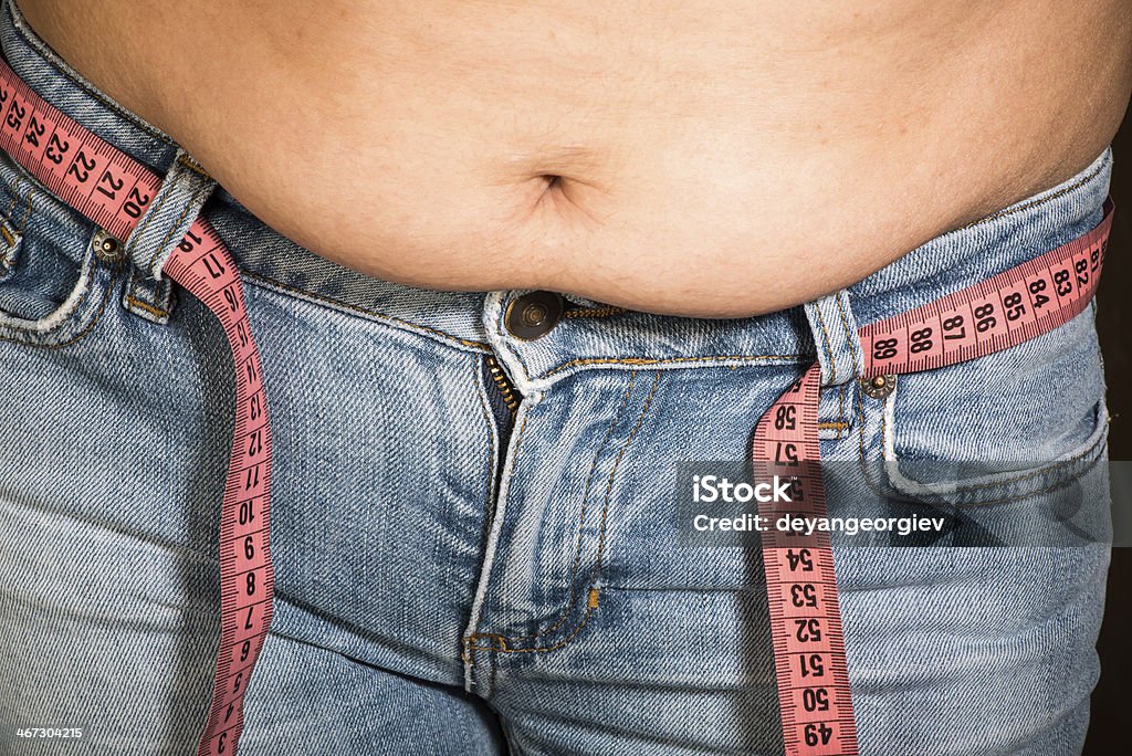 Woman showing fat belly Woman showing fat belly. Pink tape measure Abdomen Stock Photo