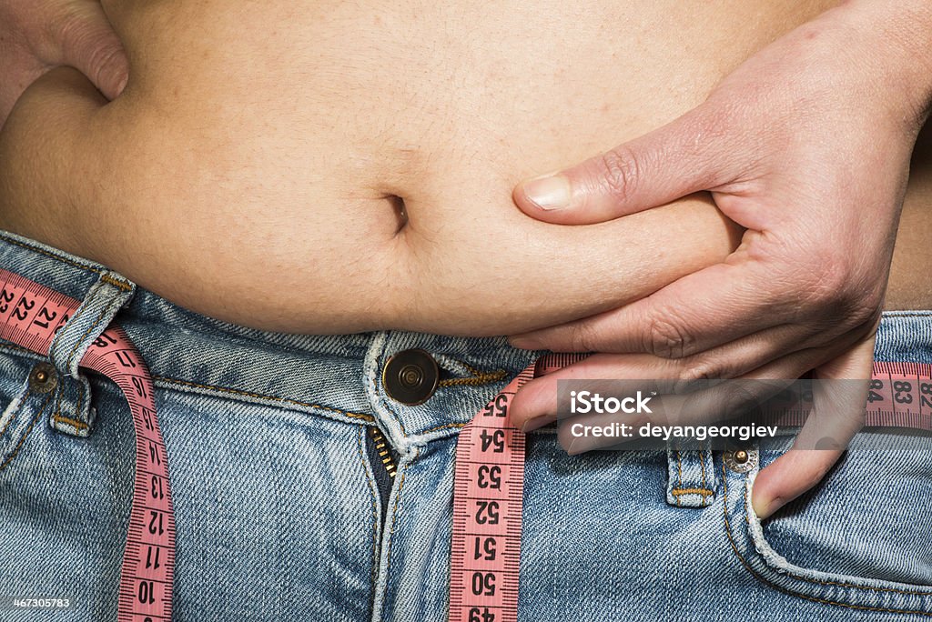 Vientre de mujer mostrando grasa - Foto de stock de Abdomen libre de derechos