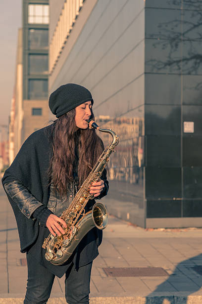 istock Beautiful young woman playing tenor saxophone 467305960