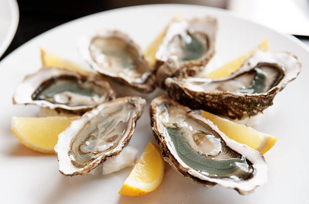 istock Fresh oysters on plate with lemon 467306133