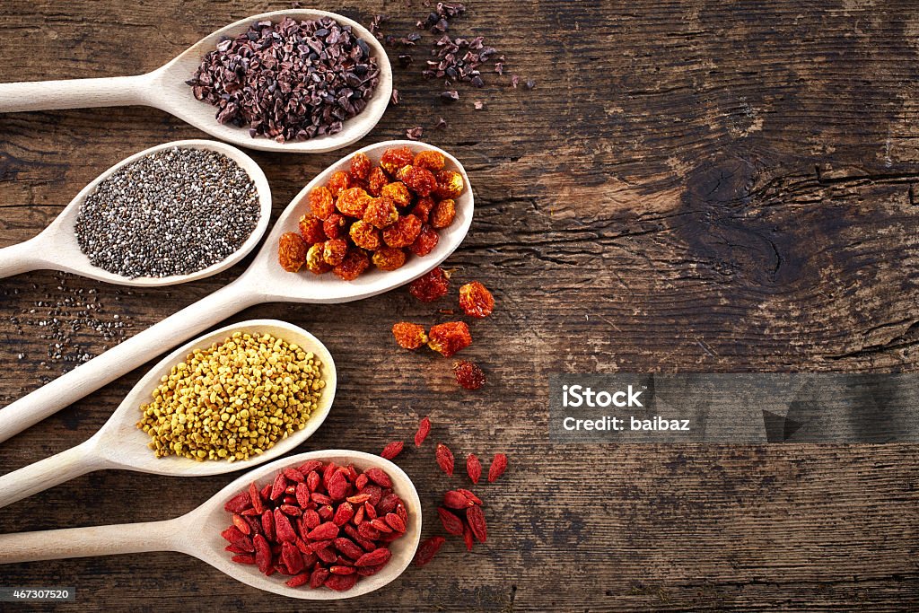 Superfoods Wooden spoons of various superfoods on old wooden background Antioxidant Stock Photo