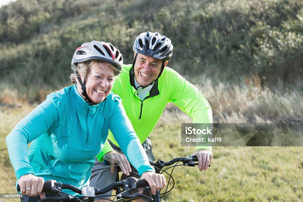 Senior couple riding bicycles Senior couple riding bicycles.  Main focus on man (60s). Cycling Stock Photo