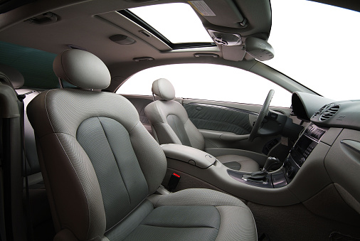 grey colored leather car seats, seatbelts, dashboard of the car from side view 