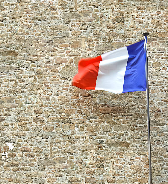 istock French flag near a stone fortress wall 467317369