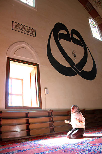 Edirne, Turkey - October 7, 2012: Muslim woman is sitting on the floor for praying and reading koran in Selimiye Mosque, Edirne Turkey