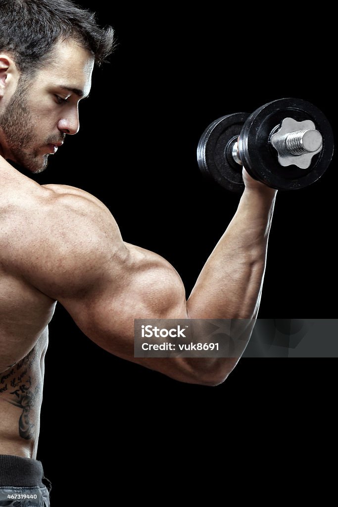 Bodybuilder Bodybuilder exercising in front of black background 20-24 Years Stock Photo