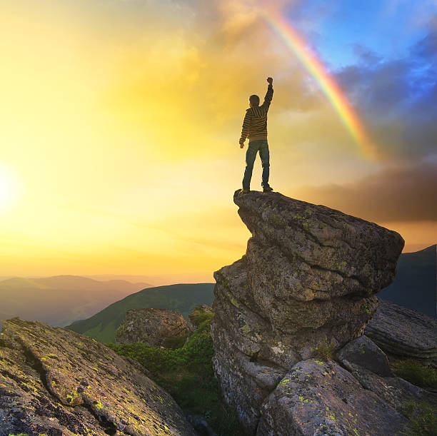 istock Silhouette of a champion standing on a cliff near rainbow 467320308