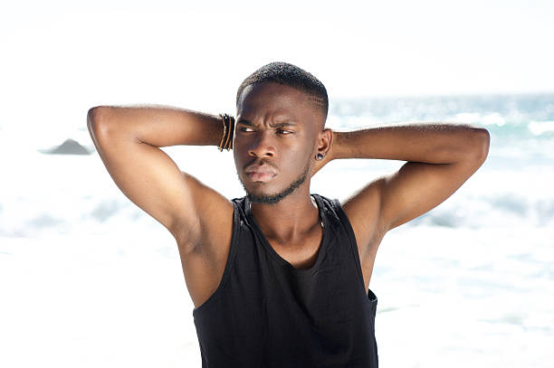 istock Attractive young man posing with hands behind head at beach 467320368