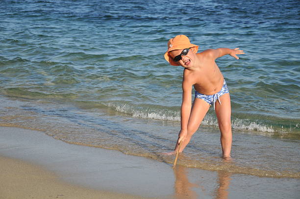 bonito rapaz em uma praia de areia - little girls fun lifestyle handcarves imagens e fotografias de stock