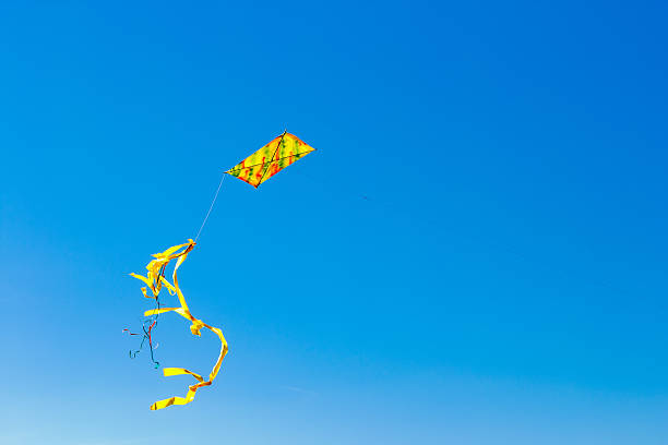 istock colorful kite with tail in blue sky 467322748