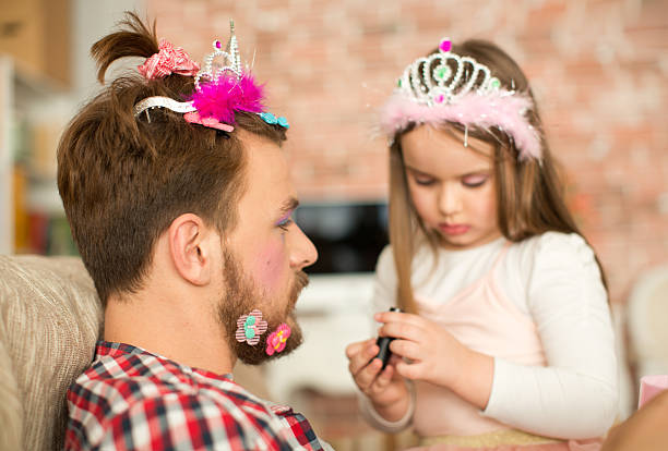 istock Cute daughter making up her father. 467325492