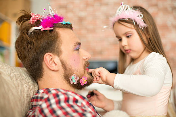 istock Cute daughter making up her father. 467325500