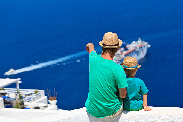 istock father and son looking at Santorini, Greece 467325697