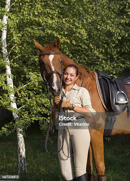 Foto de Retrato De Jovem Sorridente Brunette Mulher Com Um Cavalo Marrom e mais fotos de stock de Adestramento