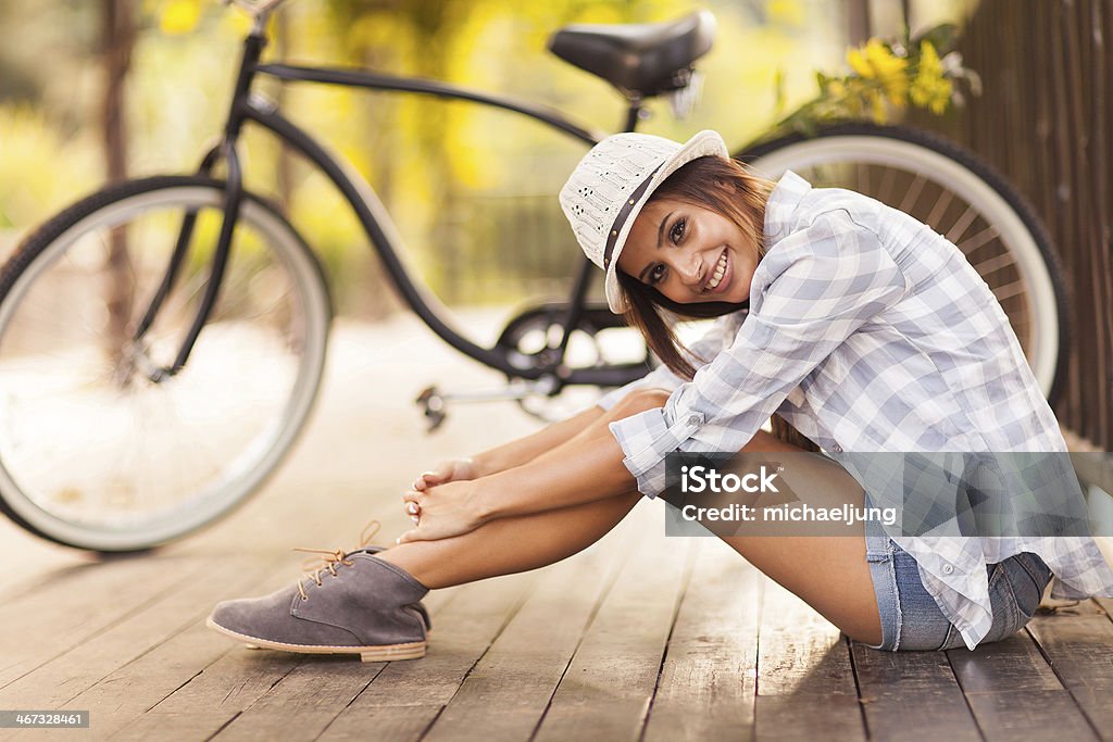 Giovane donna seduta accanto al suo moto all'aperto - Foto stock royalty-free di Donne