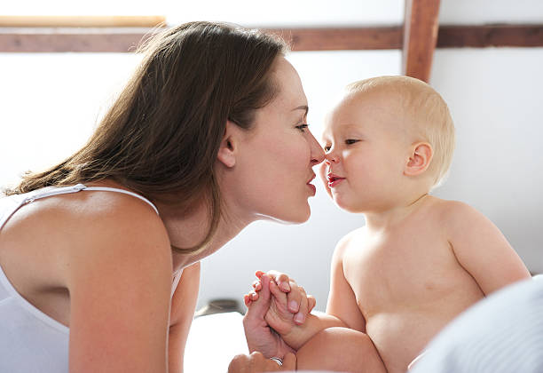 istock Beautiful woman and baby playing on bed 467330849