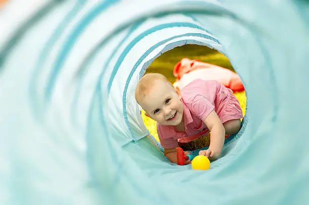 Photo of Baby playing inside a toy tunnel