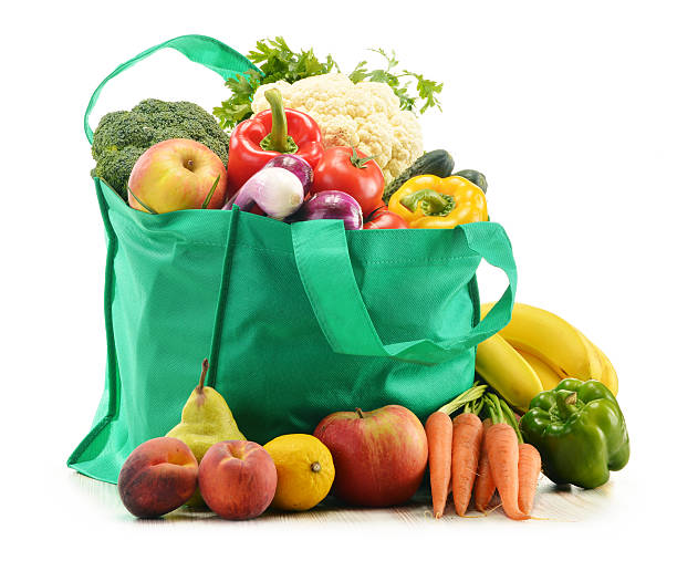 istock Green shopping bag with assorted vegetables and fruits on white 467332595