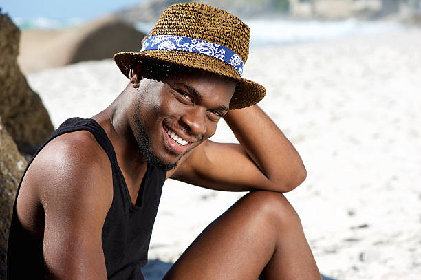 istock Smiling young man relaxing at the beach 467334752