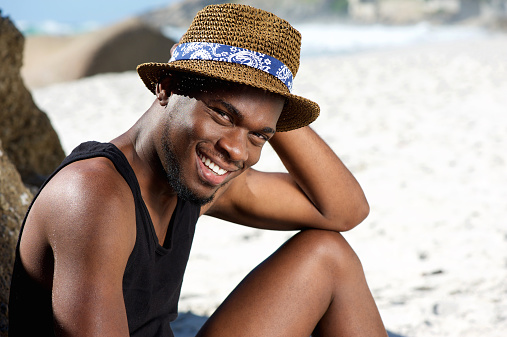 Close up portrait of a smiling young man relaxing at the beach