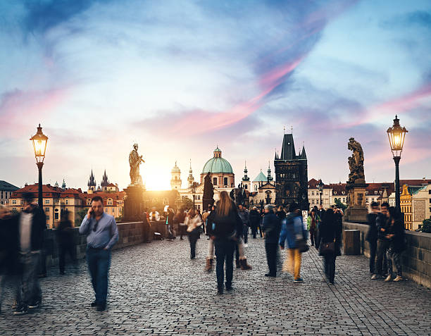 Tourists walking over the Charles bridge (Prague, Czech Republic) at sunset.