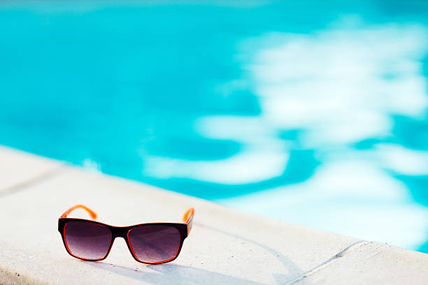 istock Orange Sunglasses by the swimming pool 467336141