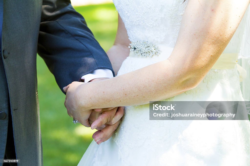 Bride and Groom Hands This bride and groom hold hands romantically while kissing on their wedding day. Bride Stock Photo