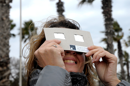 Barcelona, spain. March 20. 2015. Woman wearing special filtered sun glasses, ideal to look at the solar eclipse