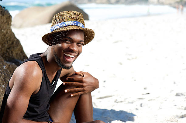 istock Happy guy sitting at the beach with hat 467346098