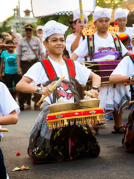 indonésia pré-adolescentes menino jogando bonang metallophones durante desfile ngrupuk - ogoh imagens e fotografias de stock