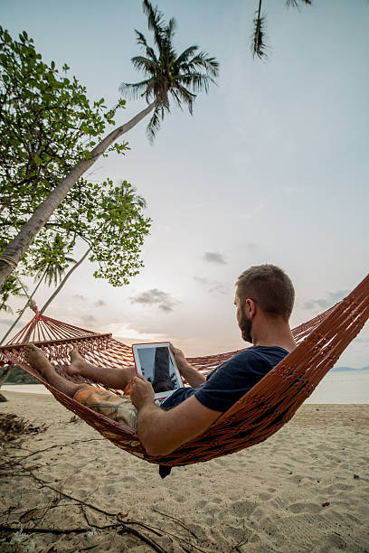 e-reader na rede-praia tropical - reading beach e reader men - fotografias e filmes do acervo