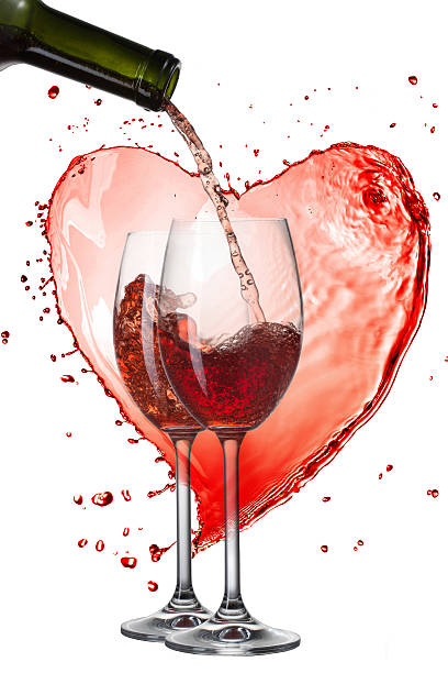 istock Red wine pouring into glasses with splash against heart isolated 467348199