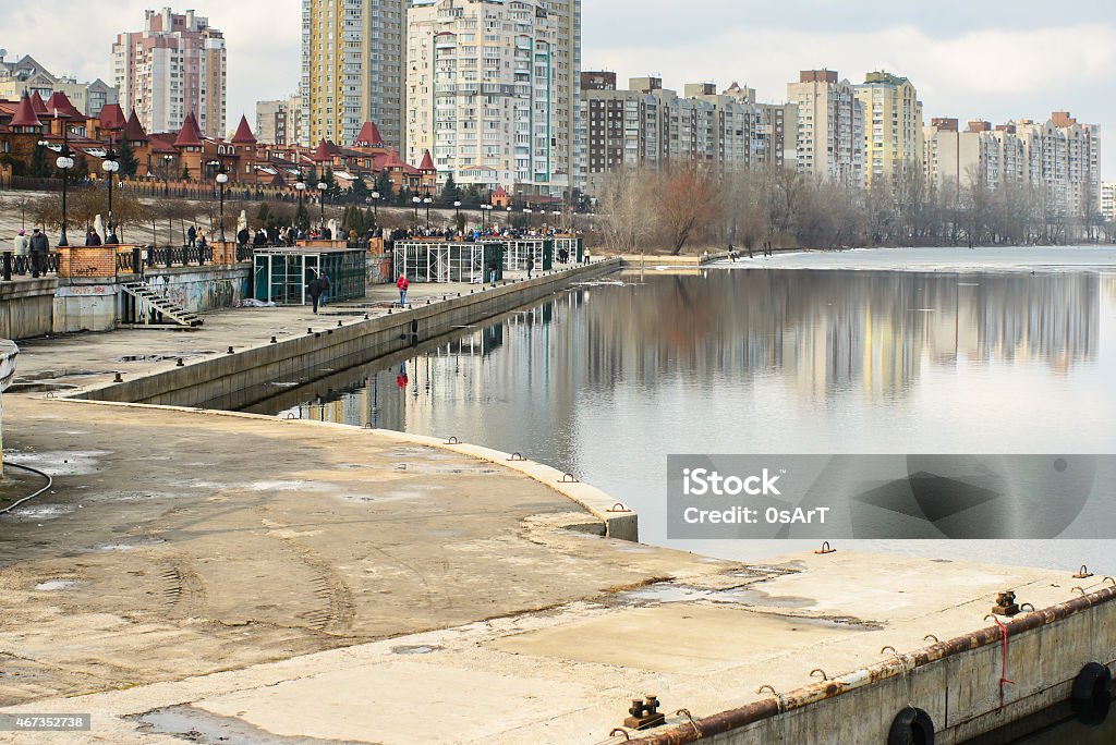 First march of spring in Ukraine city Kiev Quay in front of city with walking people near the river. First march of spring in Ukraine city Kyiv. Establishing shot 2015 Stock Photo