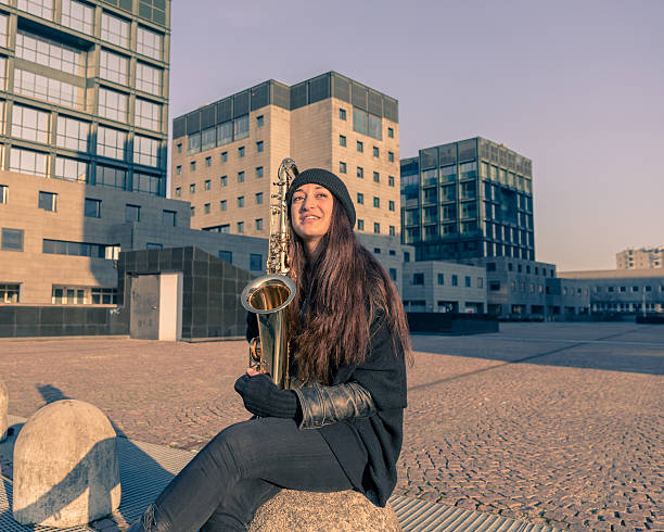 istock Beautiful young woman with her saxophone 467356104