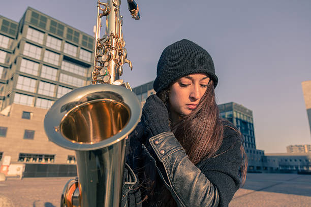 istock Beautiful young woman with her saxophone 467356106