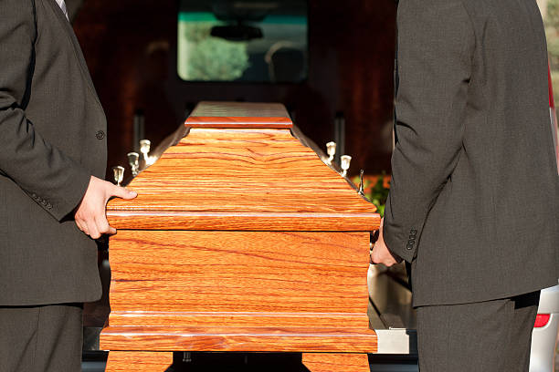 Funeral with casket carried by coffin bearer Dolor - Funeral with coffin on a cemetery, the casket carried by coffin bearer hearse photos stock pictures, royalty-free photos & images