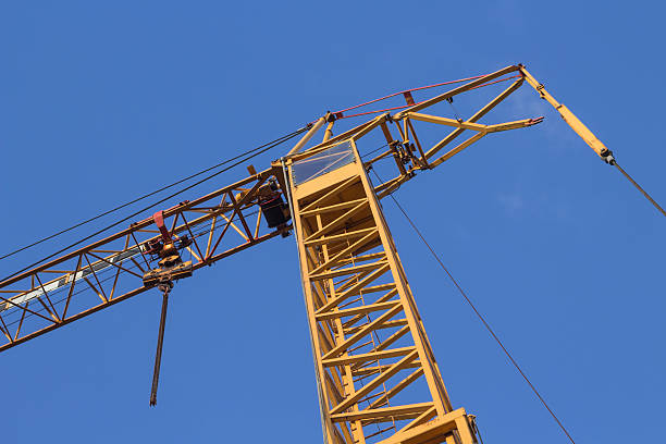 yellow construction crane in front of a blue sky stock photo