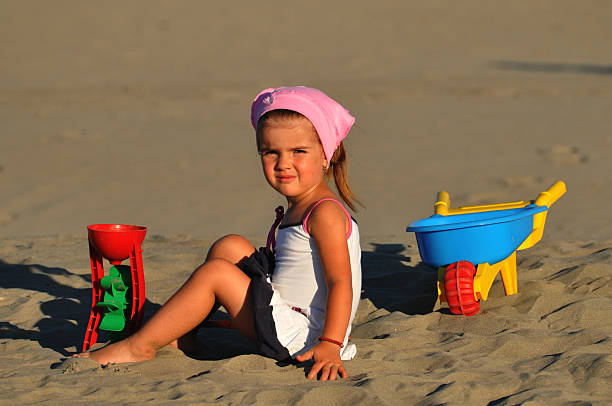 linda menina em uma praia de areia - little girls fun lifestyle handcarves imagens e fotografias de stock