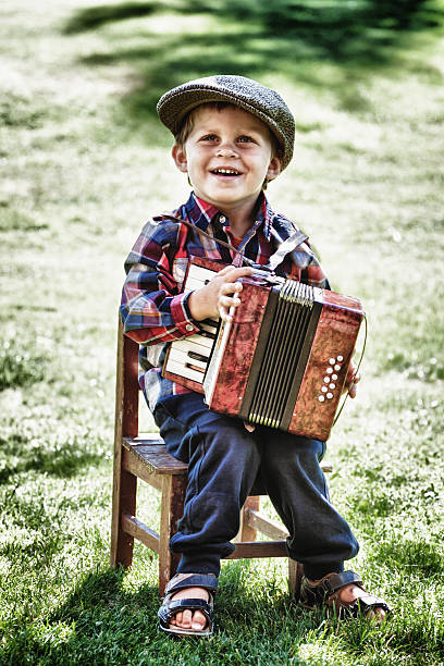 istock boy smiling and playing accordion 467362851