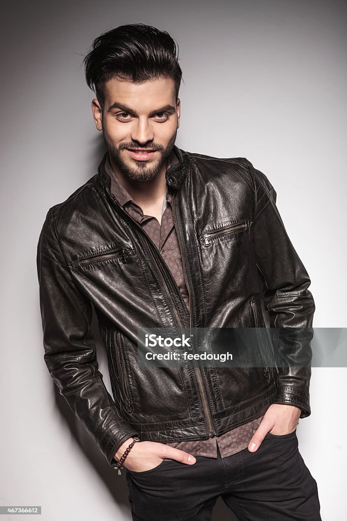 fashion man posing against white wall Happy fashion man posing against white wall with his hands in pockets. 2015 Stock Photo